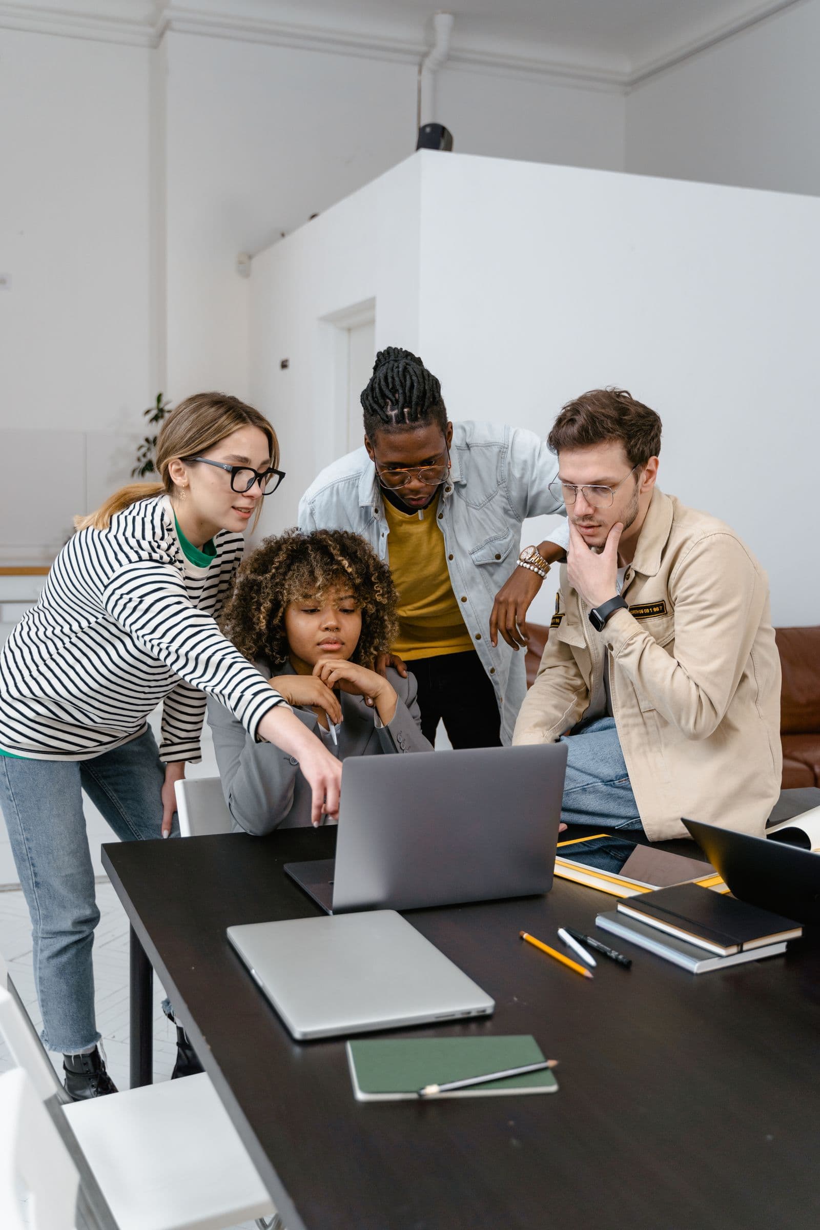 Imagem ilustrativa de uma equipe jovem e diversa colaborando em torno de um notebook